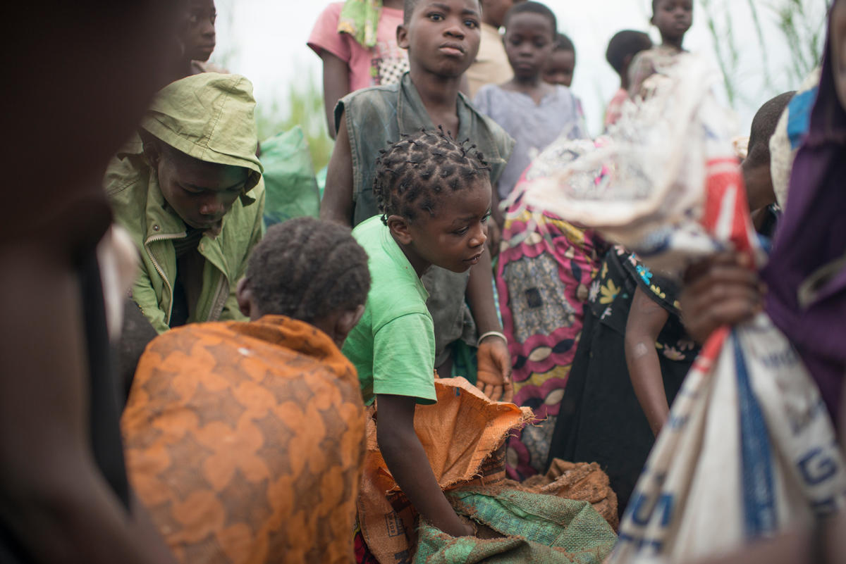 Displaced women and children in the Democratic Republic of the Congo pack sand into bags to earn money.