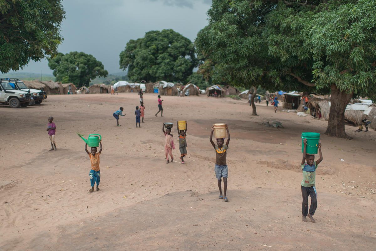 Congolese children carry buckets of water on their heads as they return to their shelters at Kaseke, a site for internally displaced people in war-torn Tanganyika Province.