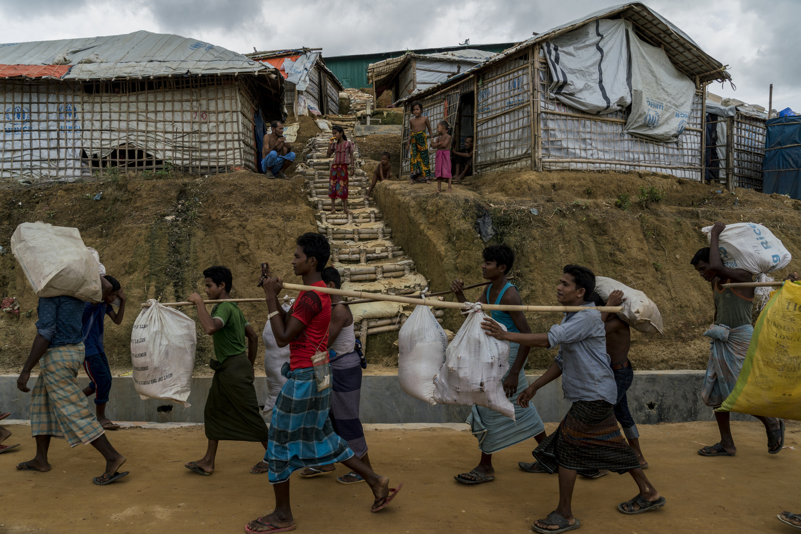 Rohingya refugees, who were living in tents at risk of landslides in Kutupalong Camp 5, carry their belongings as they are relocated to the new Camp 4 Extension, in Kutupalong refugee camp in Bangladesh on June 30th, 2018.