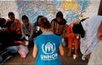 A UNHCR staff member interviews asylum seekers who have just arrived b...
