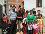 Ukshin with his family at their home. His new vehicle is in the backgr...