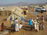 UNHCR staff assist forcibly displaced people at a tented settlement in...