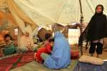 Displaced Pakistani women and children enjoy some privacy in a UNHCR t...