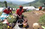 A woman cleans clothes in a hillside camp for the internally displaced...