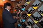 Ricardo selects a bottle of wine for a discerning customer.
