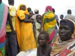 Hawa and her nine-year-old daughter, Asha, wait patiently as the reloc...