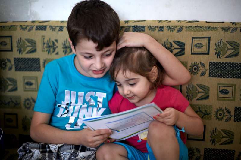 Mahmoud reads to his two-and-a-half-year old sister, Bisam, in their home in the Beit Al Aila neighbourhood in the 6th of October City.  