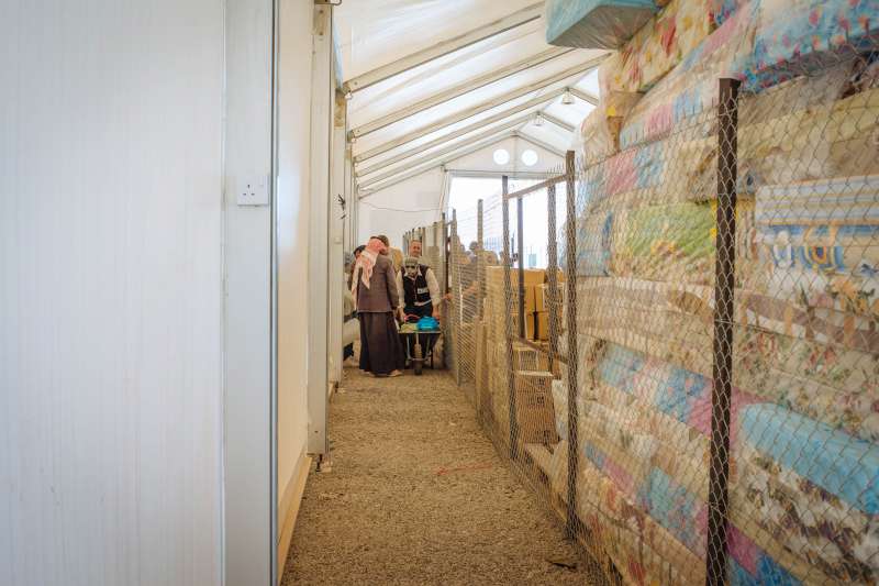 Abu Saleh visits this Norwegian Refugee Council warehouse to get basic aid items for his family. The store is piled high with mattresses and other relief supplies.