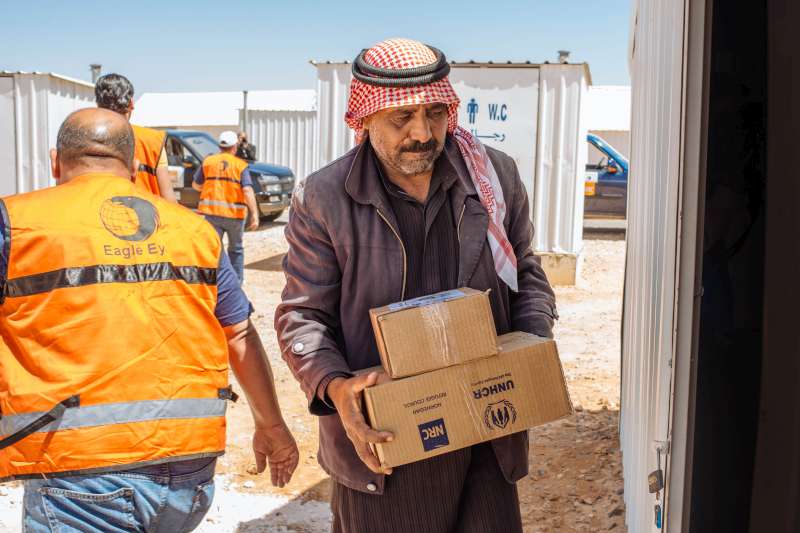 Abu Saleh carries an aid pack into his shelter. "I am very grateful for the kindness and support we have received," he says. "The shelter is much better than we had anticipated."