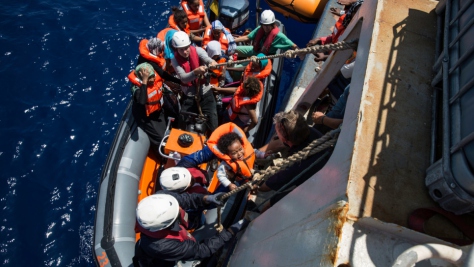 Crew from a Sea Watch search and rescue vessel rescue survivors from a boat that foundered trying to cross the Mediterranean to Europe from Libya in 2016.