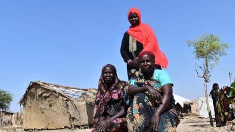 Sudan. Nyalam, Triza and Suzana stand together where the floods devastated many of the shelters in Al Redis 1 refugee camp