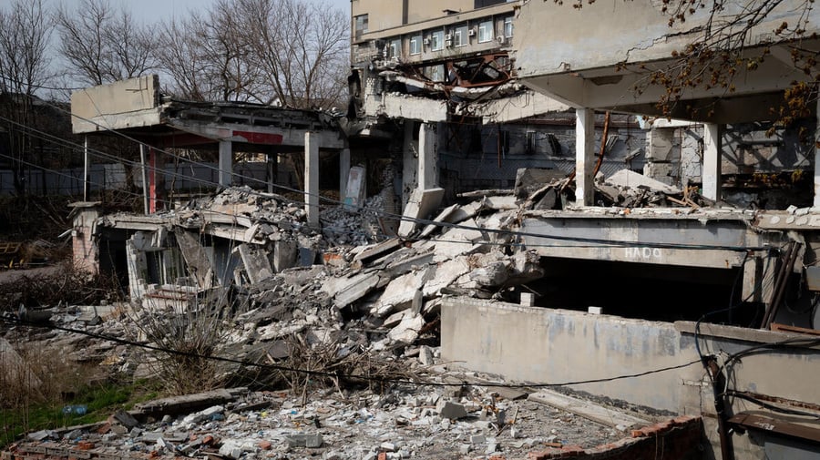 An exterior view of war-damaged buildings with collapsed roofs and walls. An exterior view of war-damaged buildings with collapsed roofs and walls.