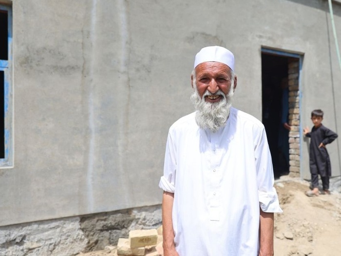 Afghan returnees in front of his newly built house