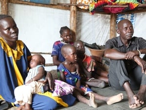 Joseph and his family sit inside their shelter in Luakdong refugee camp in Ethiopia.