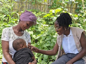 Psychologist Ancila shares a joyful moment with Viaze Abudo and her baby.