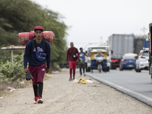 Angelo, venezolano de 22 años, camina por la carretera Panamericana hacia Tumbes, en Perú, en diciembre de 2021.