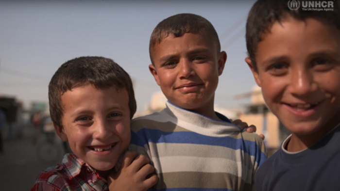 Three young boys smile at the camera