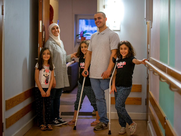 Hanan and Ali and their three daughters smile for the camera.  