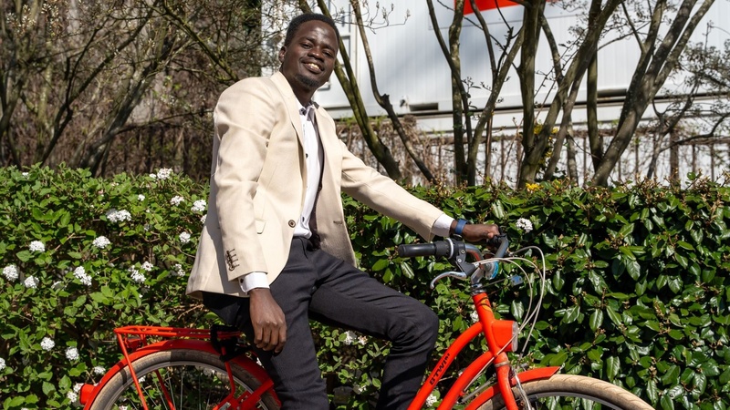 Stephen poses for the photo, sitting on his red bike