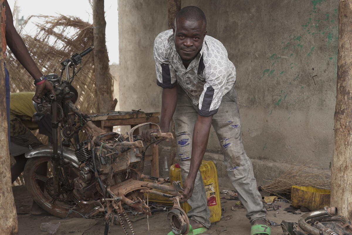 Côte d'Ivoire. Mechanic and Asylum seeker Issouf Coulibaly repairs motorcycles in Laleraba where he sought refuge after fleeing conflict in Burkina Faso.
