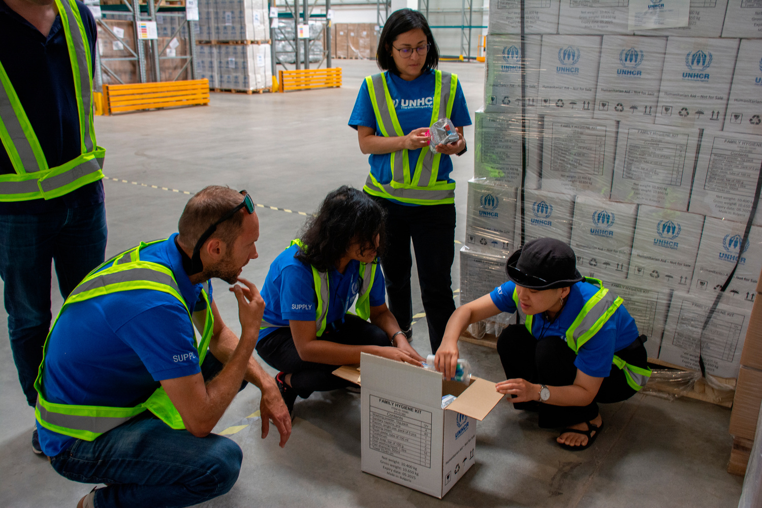 Members of the supply team inspect the contents of a family hygiene kit.