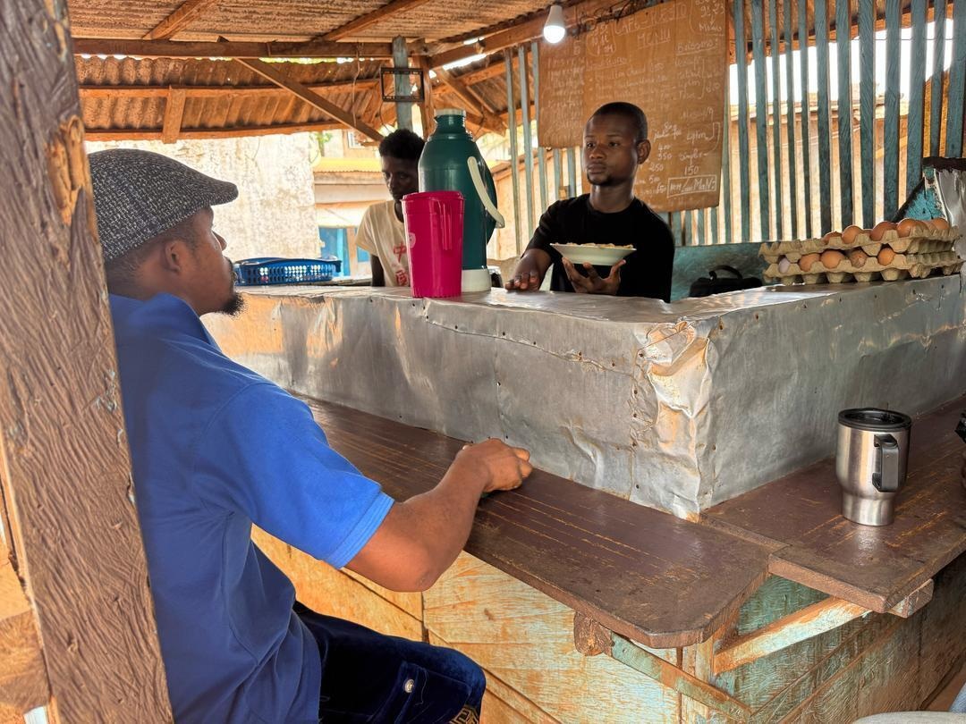 Cameroon. Haphizou CAR refugee serves fried spaghetti and eggs at his cafe restaurant