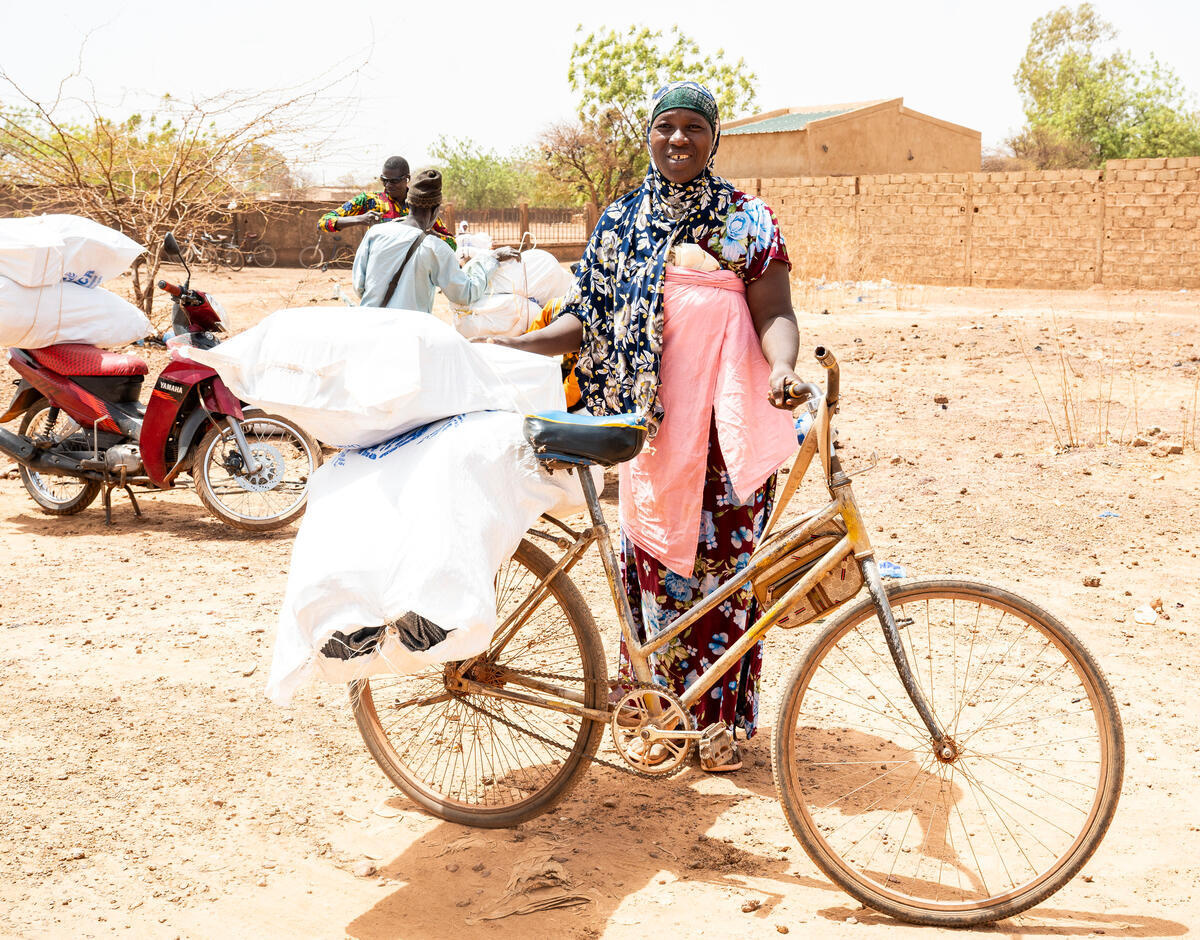 Burkina Faso. Displaced beneficiary carrying her core relief item kit