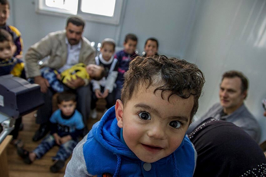 A young boy queues up with his family to be registered at the UNHCR registration offices in Amman, Jordan
