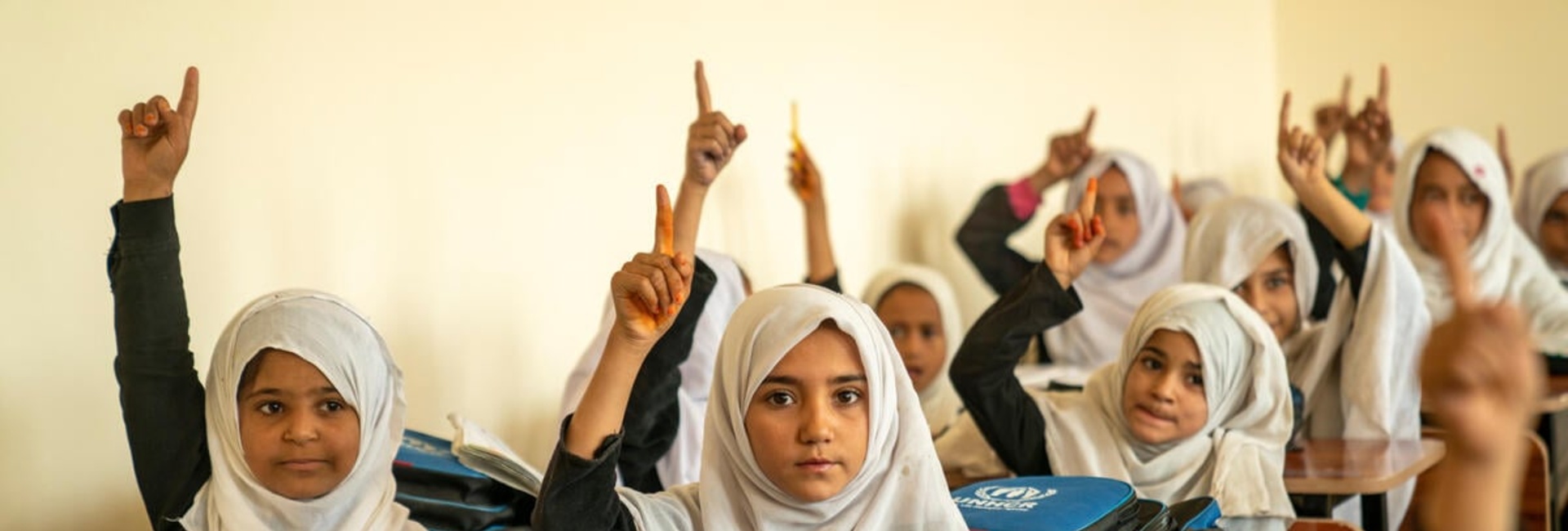 Girls raise their hands in a high school classroom in Jalalabad, Afghanistan.