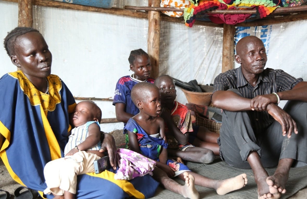 Joseph and his family sit inside their shelter in Luakdong refugee camp in Ethiopia.