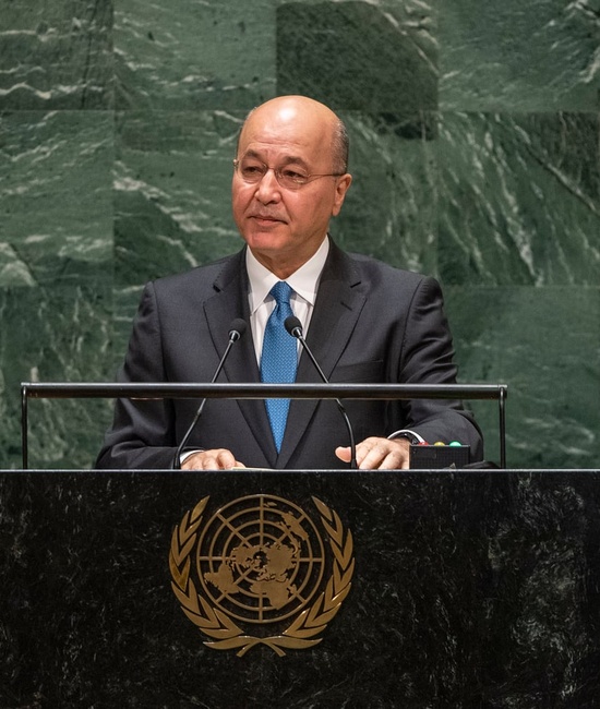 Barham Salih, wearing a suit, speaks at a podium bearing the United Nations emblem