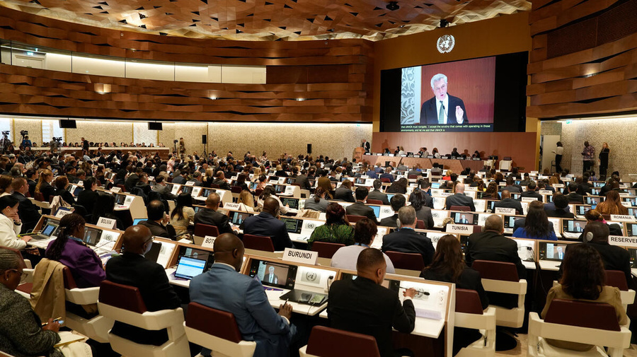 Government representatives watch the High Commissioner speak on a screen inside the Palais des Nations.