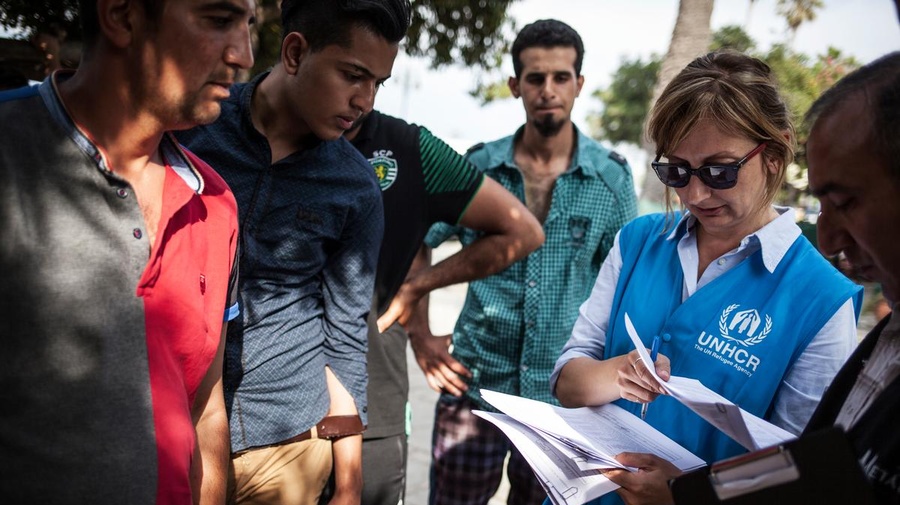 UNHCR staffer helps refugees and migrants to register at the local police station on Kos Island in Greece.