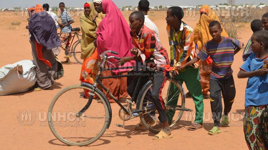 Kenya. Somali children share bicycle in Ifo 2 camp