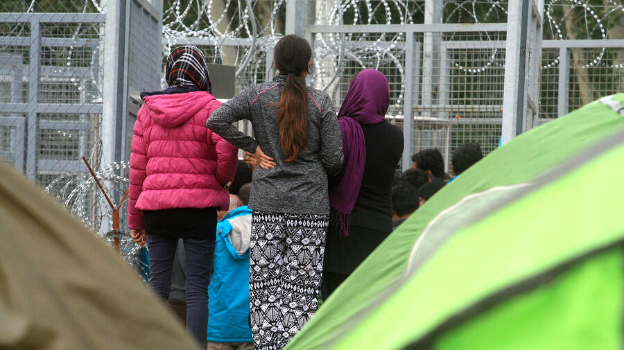 Hungary. Afghan refugee girls patiently waiting as someone is granted access to the tranzit zone in Röszke