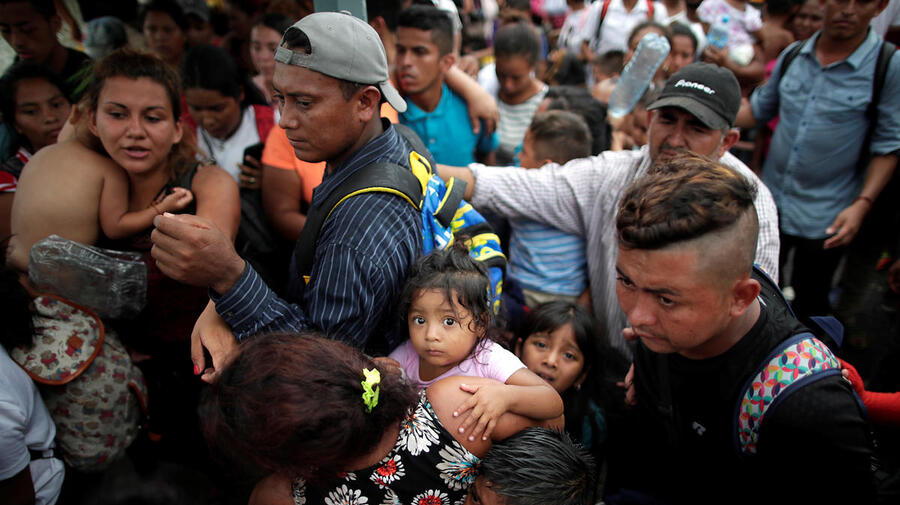 Children of Central American migrants wait with their parents to apply for asylum in Mexico at a checkpoint in Ciudad Hidalgo