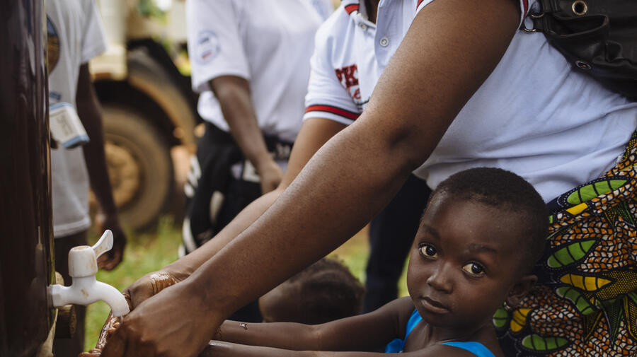 Liberia. Refugees queue for a health screening at the border with Côte d'Ivoire
