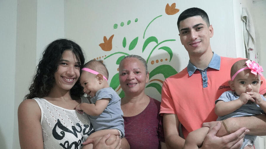 Venezuelan refugee María* poses for a portrait with her family in Medellín, Colombia. Kept inside by coronavirus stay-at-home orders, they are struggling to pay for basics like groceries and rent.