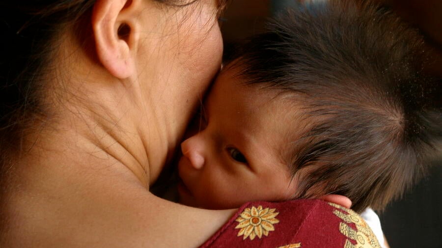 Turkmenistan. A woman holds her infant