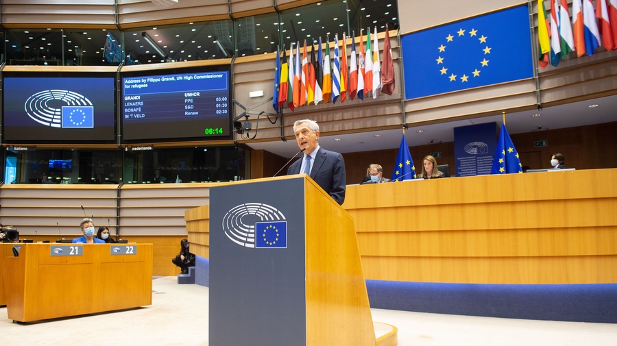 Filippo Grandi speaks at a podium, the European flag is visible behind him. 
