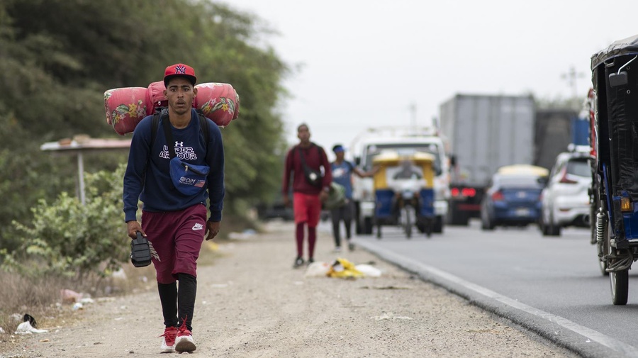 Angelo, venezolano de 22 años, camina por la carretera Panamericana hacia Tumbes, en Perú, en diciembre de 2021.