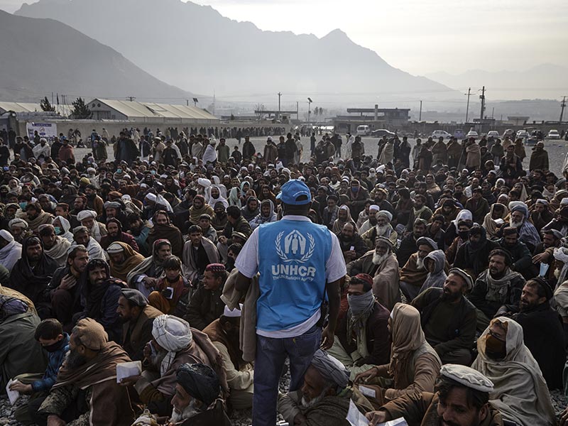  A UNHCR staff member assists displaced families waiting to receive cash assistance in Kabul, Afghanistan