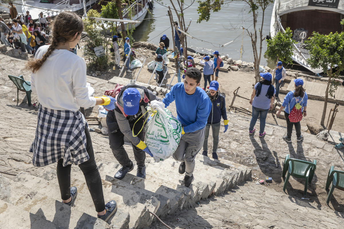 Egypt. Refugees and locals clean the Nile together