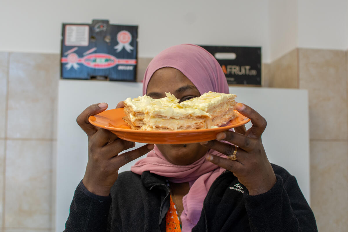 Mariam (34), from Eritrea, presents her first ever tompouce, made during a cooking workshop at the Emergency Transit Centre in Timisoara, Romania.