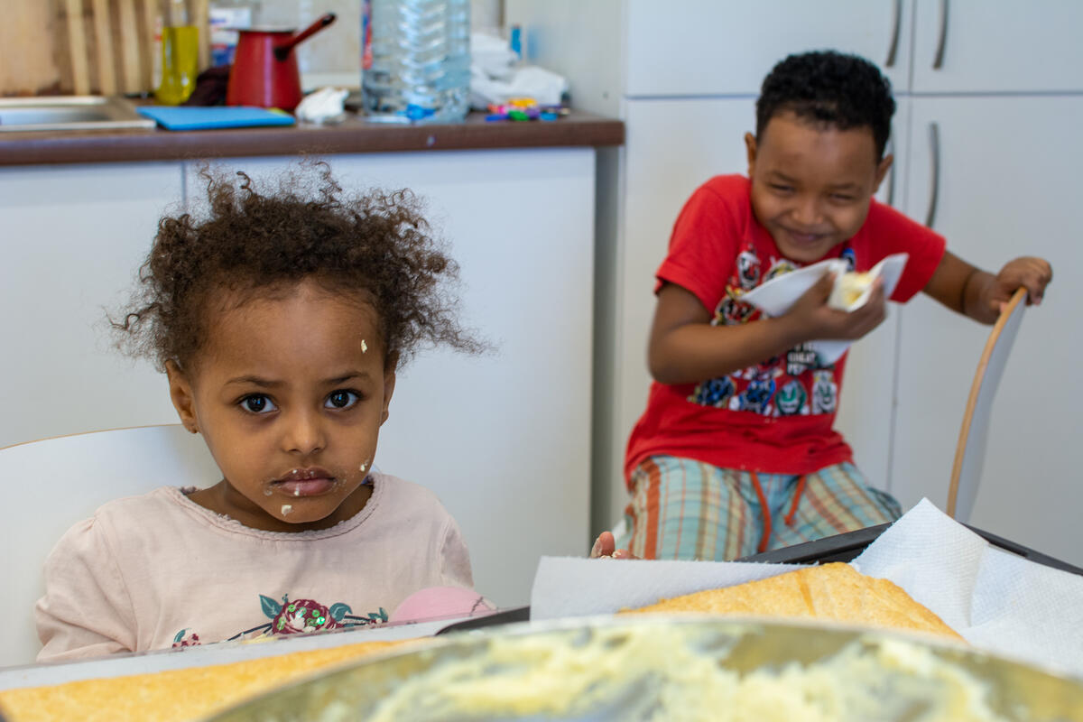 Feruz (5) and Karim (7) eating the tompouce their mother made during a cooking workshop organized by AIDRom, UNHCR's partner in the Emergency Transit Centre in Timisoara, Romania.