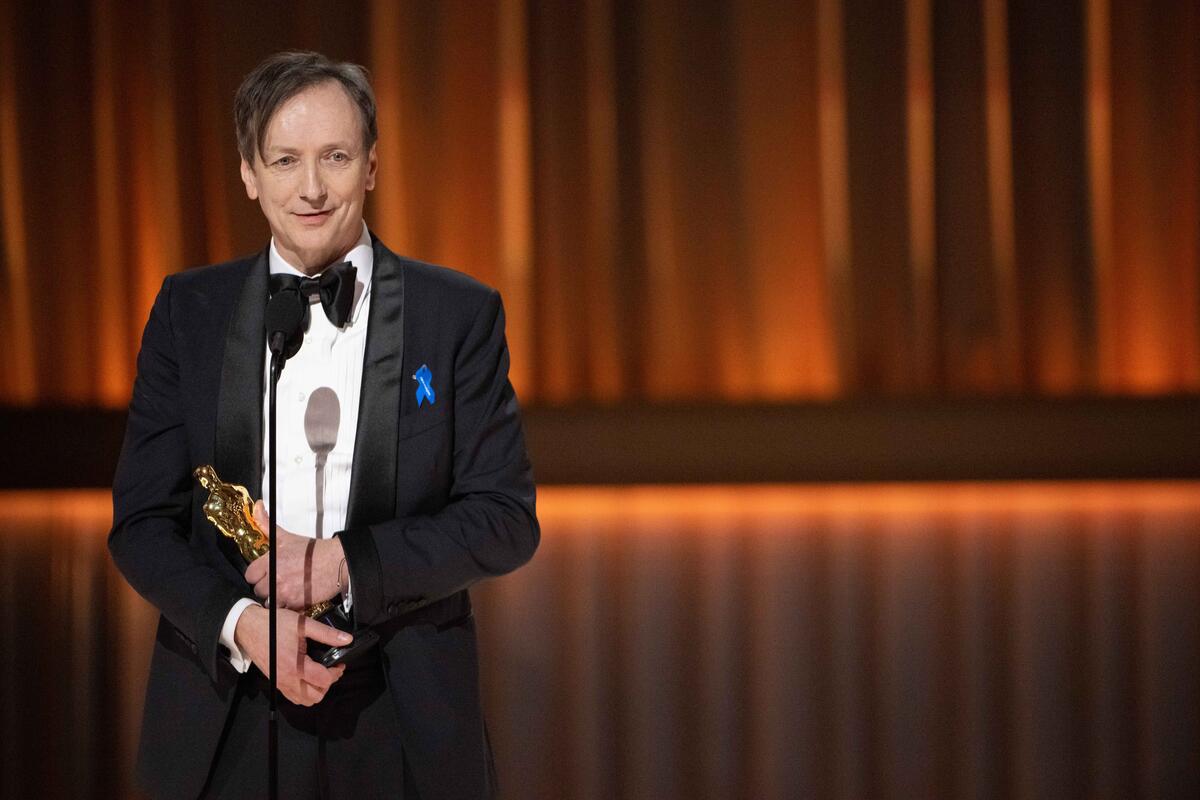 United States. Volker Bertelmann accepts the Oscar for Original Score during the live ABC telecast of the 95th Oscars and wears a blue ribbon in solidarity with refugees