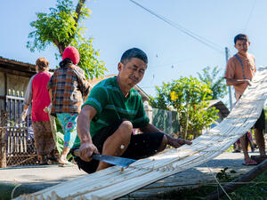 Community volunteers at a camp in Kachin State come together to help reconstruct a community hall, a venue frequently utilized for meetings and other communal events.