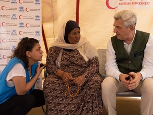 A Sudanese refugee woman speaks to UN officials inside a tent.