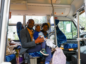 A couple and their young son sit in a bus.