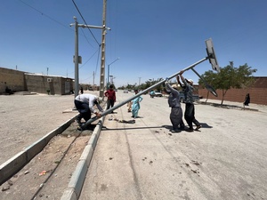 Workers put up a solar street light in Bardsir settlement, Iran.